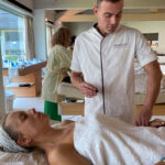 Esteticista aplicando un tratamiento facial con cosmética profesional vegana en cabina estética