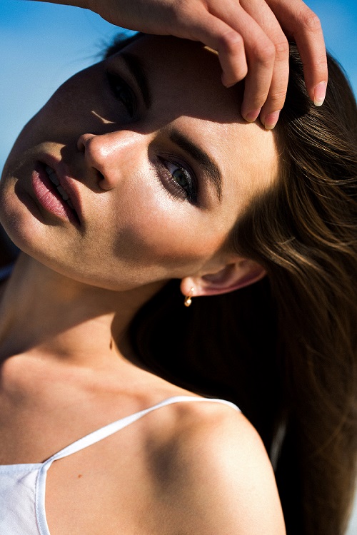 Mujer con piel luminosa y bronceada usando cosmética solar profesional Vagheggi.