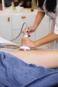 Mujer recibiendo radiofrecuencia como tratamiento con productos reductores en cabina